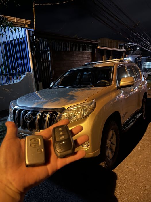 Dos llaves de proximidad nuevas frente a un Toyota Prado
