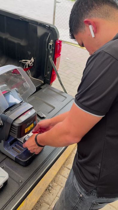 Técnico de OPEN cortando una llave en la máquina